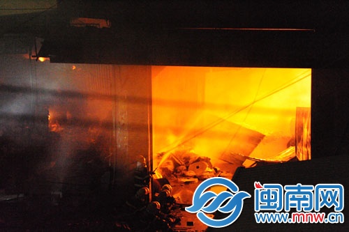 倉庫火勢很旺，消防員用水槍壓制