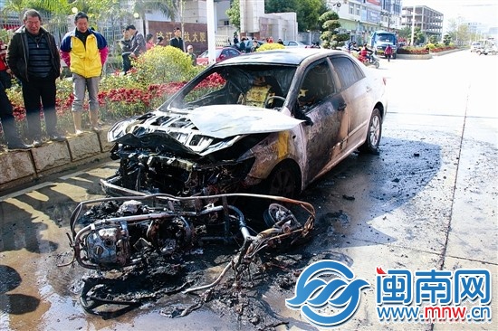 火被撲滅后，小車前躺著一輛被燒得只剩鋼架的助力車