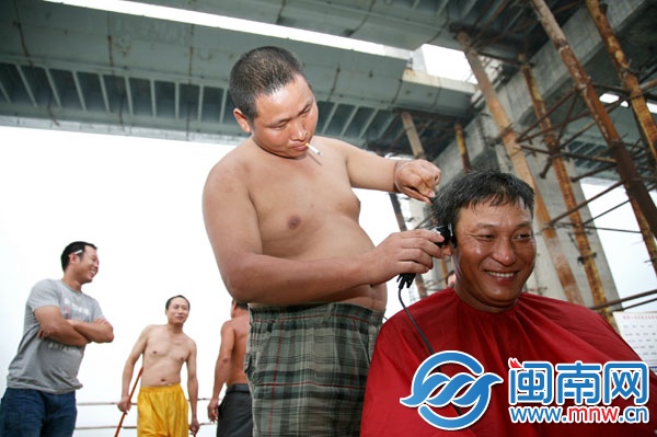 梁師傅正在給工友理發